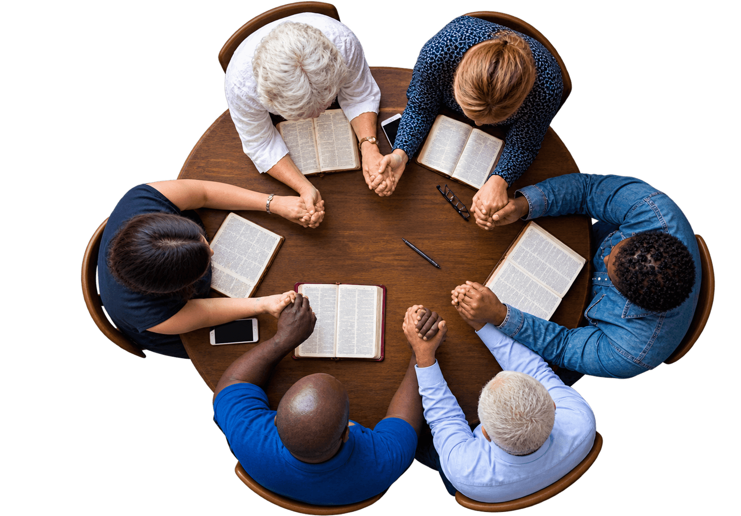 People praying together around a table with open Bibles